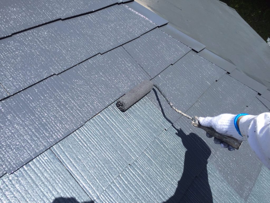ローラーで屋根を塗替えていく職人