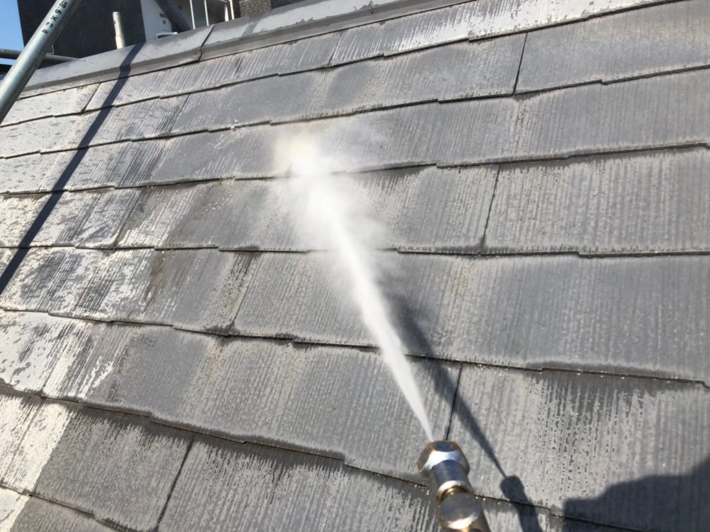高圧洗浄で屋根に付着した汚れを落としている